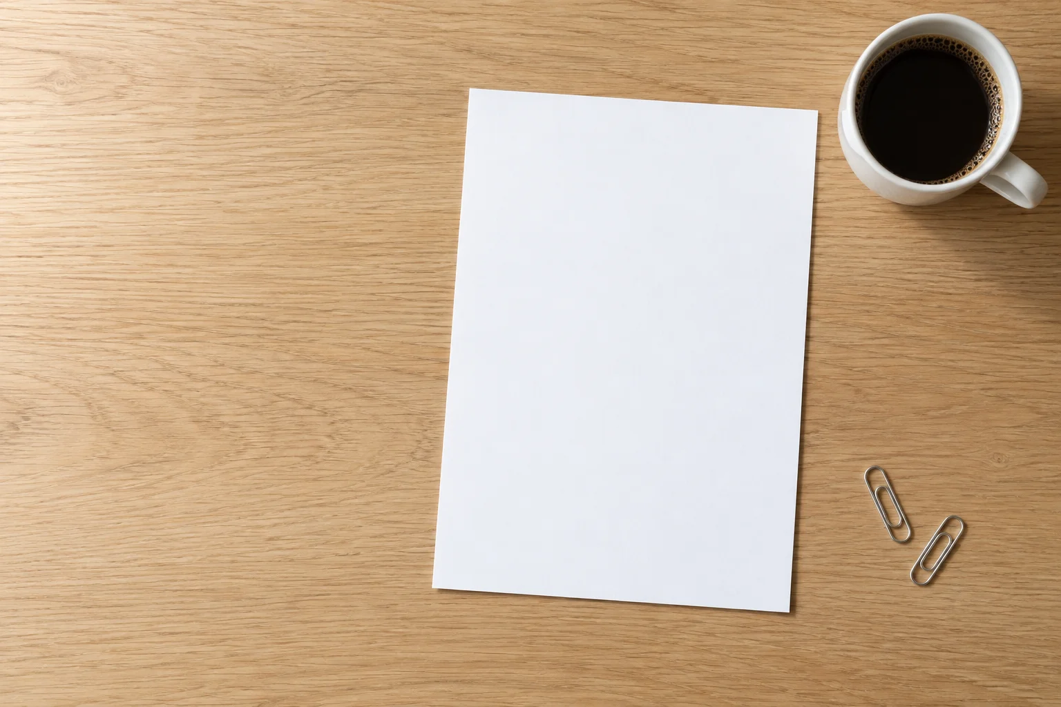 An invoice for Discovery on an oak desk beside a coffee and a sticky note